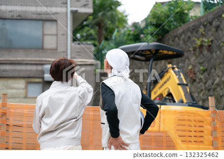 Construction site: Woman in work clothes, man in workwear 132325462
