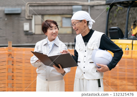 Construction site: Woman in work clothes, man in workwear 132325476