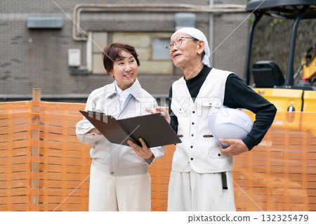 Construction site: Woman in work clothes, man in workwear 132325479
