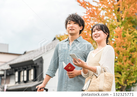 A young Asian couple searching for tourist spots while looking at their smartphone A young Asian couple searching for tourist spots while looking at their smartphone 132325771