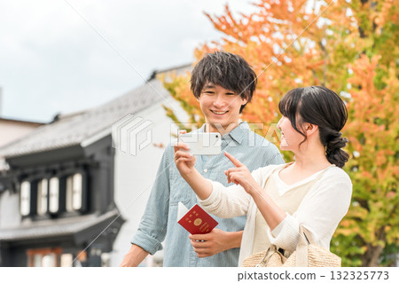 A young Asian couple searching for tourist spots while looking at their smartphone 132325773
