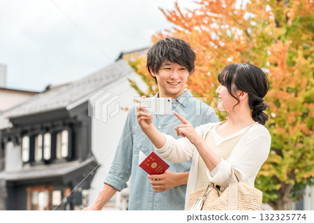 A young Asian couple searching for tourist spots while looking at their smartphone 132325774