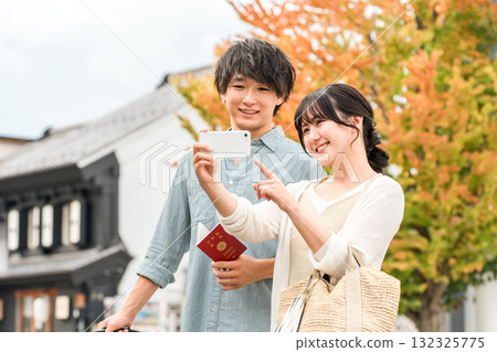 A young Asian couple searching for tourist spots while looking at their smartphone 132325775