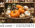 Store displaying decorative pumpkins and gourds in woven basket. Thanksgiving Day seasonal decoration with berries and foliage. 132325873