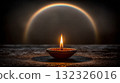 Illuminated Diya with Colorful Rainbow in Background during a Dark Moment 132326016