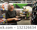 Woman shopping in a store for kitchen supplies with a focus on cookware and utensils 132326634