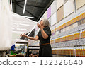 Woman in store examines fabric while shopping for home improvement supplies in bright, well 132326640