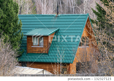 Green roof of a private house among trees in a forest. Green roof of a private house among trees in a forest. 132327123