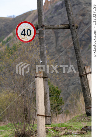 A road sign on a wooden post at the edge of a country road. 132327159