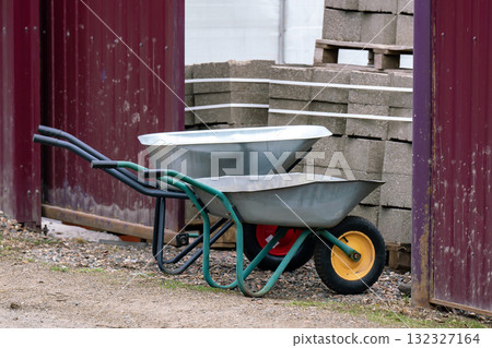 Two wheelbarrows on one wheel for house construction. Two wheelbarrows on one wheel for house construction. 132327164