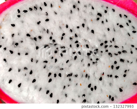 Close-up of white dragon fruit flesh with black seeds. Close-up of white dragon fruit flesh with black seeds. 132327993