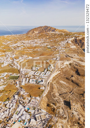 Drone photo capturing the expansive volcanic landscape and scattered white villages of Santorini 132329472