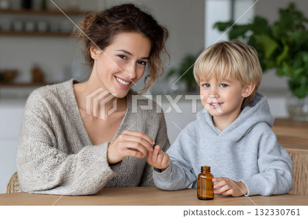 Happy Mother and Child Holding Vitamin Capsules Bottle Happy Mother and Child Holding Vitamin Capsules Bottle 132330761