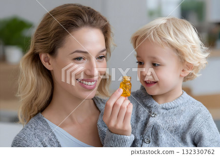 Happy Mother and Child Holding Vitamin Capsules Bottle 132330762