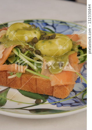 Delicious open-faced toast topped with greens and eggs 132330844
