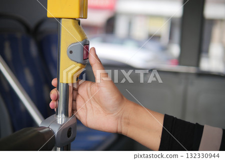 Passenger pressing button for bus stop request in city Passenger pressing button for bus stop request in city 132330944