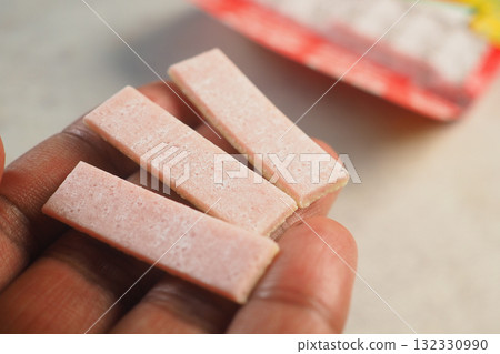 Hand holding three chewing gum  132330990