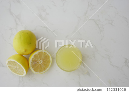 Fresh lemonade with lemons on marble countertop Fresh lemonade with lemons on marble countertop 132331026