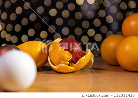table with oranges and Christmas balls on a background of defocused lights, xmas ball in orange peel table with oranges and Christmas balls on a background of defocused lights, xmas ball in orange peel 132331426
