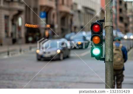 view of city traffic with traffic lights, in the foreground a semaphore with a green light, closeup 132331429