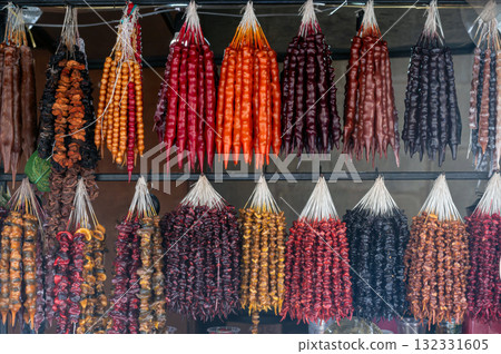 Traditional Georgian food sausage-shaped candy churchkhela hanging in market. Traditional Georgian food sausage-shaped candy churchkhela hanging in market. 132331605