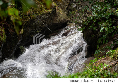 Rapid and powerful water flow between large rocks in cold mountain river, closeup Rapid and powerful water flow between large rocks in cold mountain river, closeup 132331658