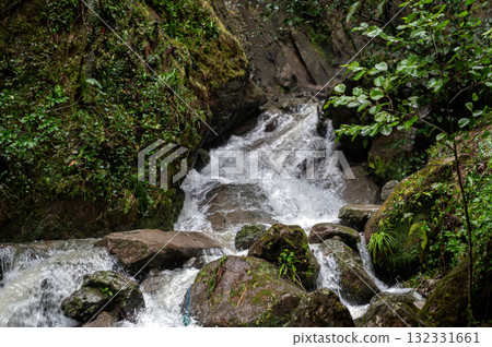 Rapid and powerful water flow between large rocks in cold mountain river, closeup 132331661