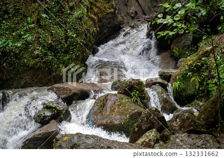 Rapid and powerful water flow between large rocks in cold mountain river, closeup 132331662