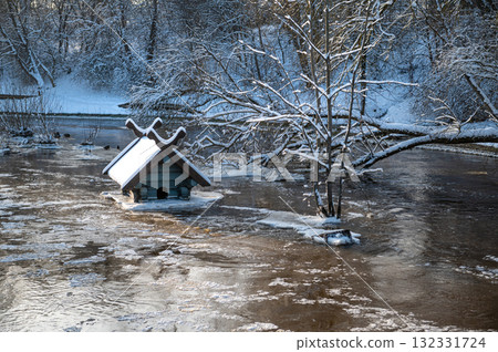 spring floods and ice melt in a small river, waterfowl feeder flooded as water level rises, Dobele spring floods and ice melt in a small river, waterfowl feeder flooded as water level rises, Dobele 132331724