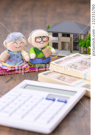 一對老年夫婦和他們的房子的縮影（加上一個計算器和一疊鈔票） 132331760