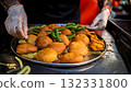 India Street Food, Vendor preparing spicy vada pav, with a side of fried green chili 132331800