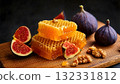 Golden honeycomb pieces placed on a wooden board with fresh figs and nuts 132331812