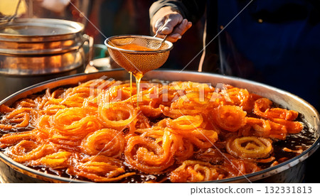 India Street Food, Golden jalebis being fried and dipped in sugar syrup at a bustling market 132331813