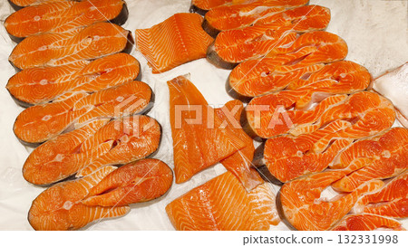 Fresh salmon fillets and steaks on ice in a fish market or supermarket display case. Healthy eating concept, seafood market, protein diet, and fresh fish. 132331998