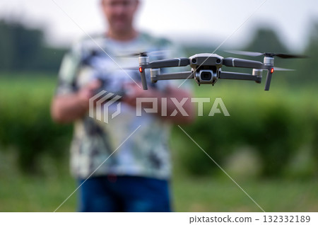 drone copter flying in the air with blurred man on background 132332189