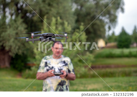 drone copter flying in the air with blurred man on background 132332196