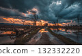 Desolate Road Through Flooded Landscape at Sunset After Stormy Sky and Fallen Trees 132332220