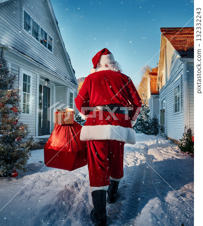 Santa claus walking through snowy village delivering presents 132332243