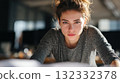 Focused Woman Leaning Forward, Looking at Camera, Close-Up Portrait in Indoor Setting 132332378