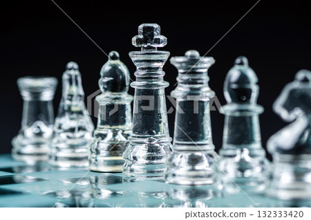 Transparent glass chess pieces on dark background. Leadership and strategy concept, selective focus Transparent glass chess pieces on dark background. Leadership and strategy concept, selective focus 132333420