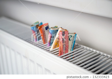 euro banknotes in a central heating radiator, the concept of expensive heating costs, closeup euro banknotes in a central heating radiator, the concept of expensive heating costs, closeup 132333423