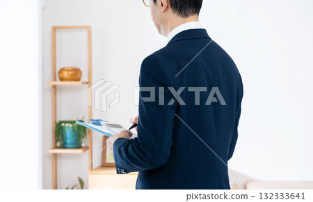 A man in a suit checking furniture 132333641