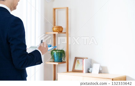 一名西裝革履的男子正在檢查家具 132333642