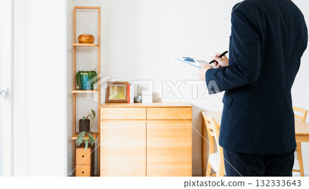 一名西裝革履的男子正在檢查家具 132333643