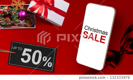 Christmas sale text on cellphone screen and Christmas ornament on giftbox with up to 50% text on the label tag. Copy space. Christmas sale concept 132333978