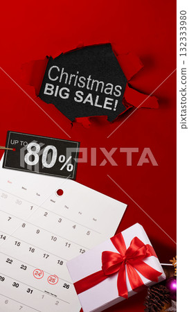 Top view of red ripped paper and text of Christmas big sale with up to 80% text on the label tag. Copy space. Flash sale concept 132333980