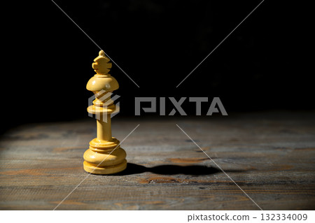 Closeup view of the white chess king standing against a dark background. Concept of leadership Closeup view of the white chess king standing against a dark background. Concept of leadership 132334009
