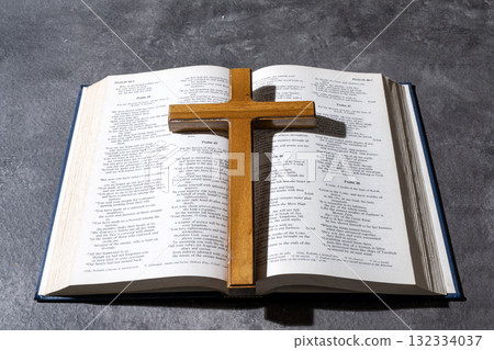 Blue book of the Holy bible and a Christian cross on the table. Symbol of faith in God. Concept of Spirituality, Christianity, religion, faith, Jesus, or belief Blue book of the Holy bible and a Christian cross on the table. Symbol of faith in God. Concept of Spirituality, Christianity, religion, faith, Jesus, or belief 132334037