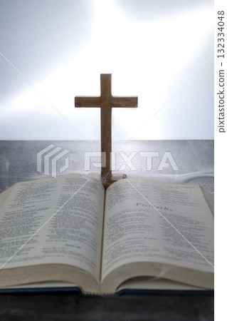 Blue book of the Holy bible and Christian cross. Standing on the table with a light background. Symbol of faith in God. Concept of Spirituality, Christianity, religion, faith, Jesus, or belief Blue book of the Holy bible and Christian cross. Standing on the table with a light background. Symbol of faith in God. Concept of Spirituality, Christianity, religion, faith, Jesus, or belief 132334048