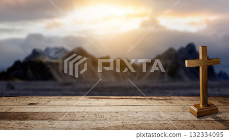 Christian cross on a wooden table with a landscape view and a dark dramatic sky background. Concept of Christianity, religious, faith, Jesus, or belief 132334095